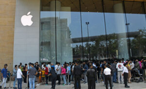People are seen standing in a queue to enter the the Apple